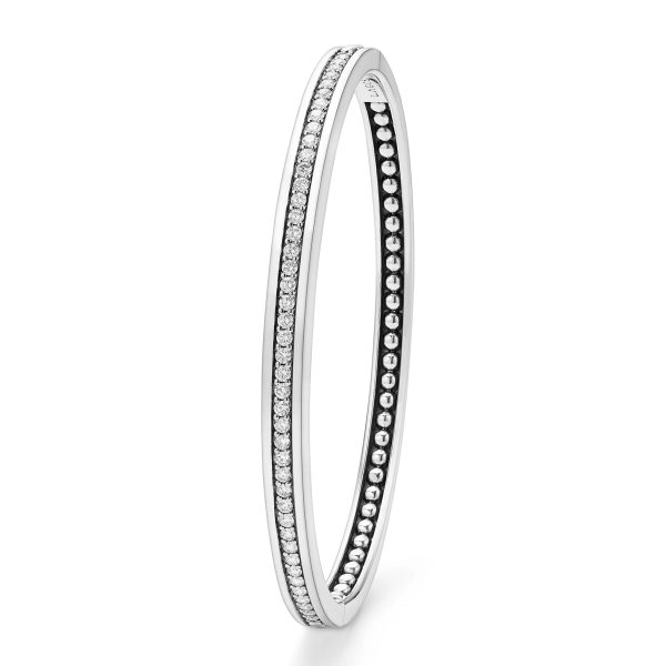 The LAGOS Caviar Spark Diamond Bangle Bracelet is a sleek silver accessory, elegantly adorned with a row of small, sparkling diamonds along its outer edge. Inside, the bracelet is enhanced with evenly spaced silver beads, providing a unique texture to its design. This bangle boasts both modern and elegant appeal.