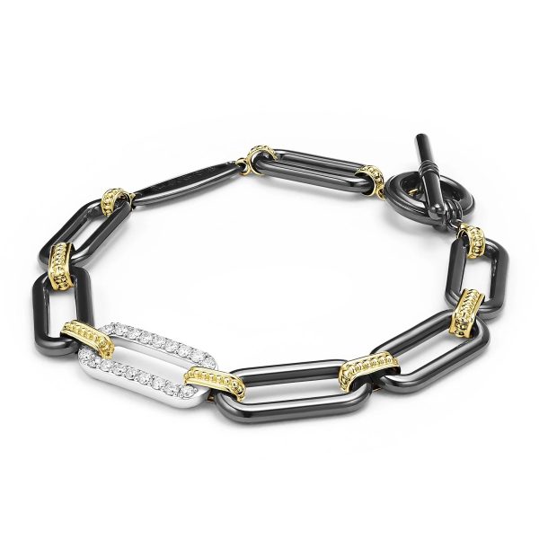 The LAGOS Signature Caviar 18K Gold and Black Ceramic Diamond Station Link Bracelet is an elegant piece, featuring large, rectangular black ceramic links interspersed with smaller gold-accented links. It includes a standout white link encrusted with sparkling diamonds and secures with a toggle clasp for closure.