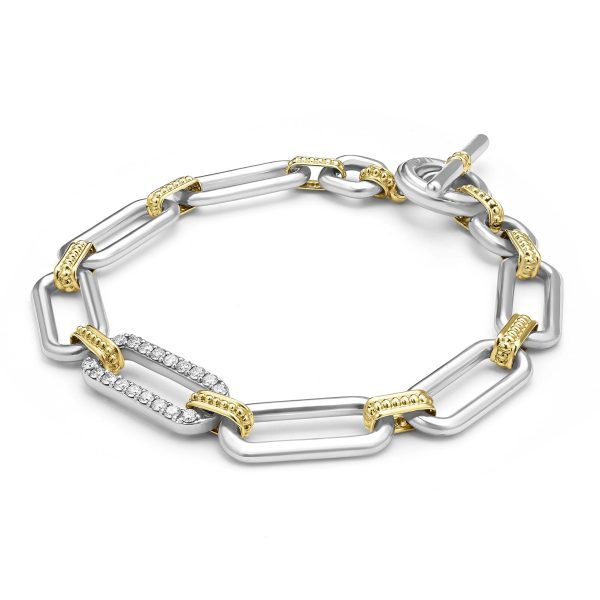 A detailed image of the LAGOS Signature Caviar Two-Tone Link Diamond Bracelet, showcasing its interlocking rectangular metal links that alternate between gold and silver tones. One section is adorned with small, sparkling diamonds, and the bracelet features a toggle clasp. The background is plain white.