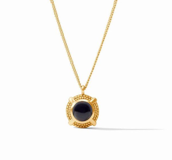 The Julie Vos Cabochon Solitaire Necklace in Obsidian Black showcases a circular gold pendant with a striking black central stone, intricately set in an ornate gold frame. Displayed against a white background, the pendant hangs gracefully from a delicate gold chain, creating a timeless and elegant design.