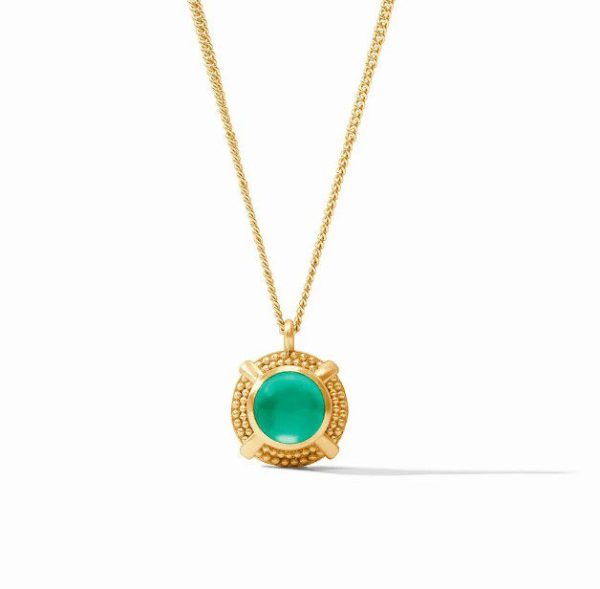 The Julie Vos Cabochon Solitaire Necklace - Iridescent Emerald Green features a gold chain with a pendant showcasing a round, iridescent emerald green gemstone set in an intricately detailed gold frame. The simple and elegant design of the chain beautifully complements the ornate setting of the pendant, displayed against a plain white background.