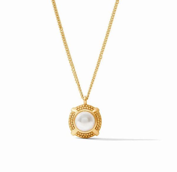 The Julie Vos Cabochon Solitaire Necklace - Pearl showcases a gold chain adorned with a round pendant that boasts a central white pearl. The pearl is elegantly encased in a decorative gold setting, adding to its refined charm. The necklace is displayed against a plain white backdrop, creating a subtle shadow effect.