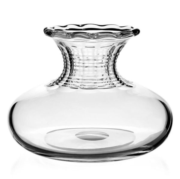 The William Yeoward Debbie Flower Centre Vase features a simple and elegant design with a clear glass composition that highlights its transparency and smooth lines. It has a wide base, a narrow, textured neck, and a scalloped, flared rim.