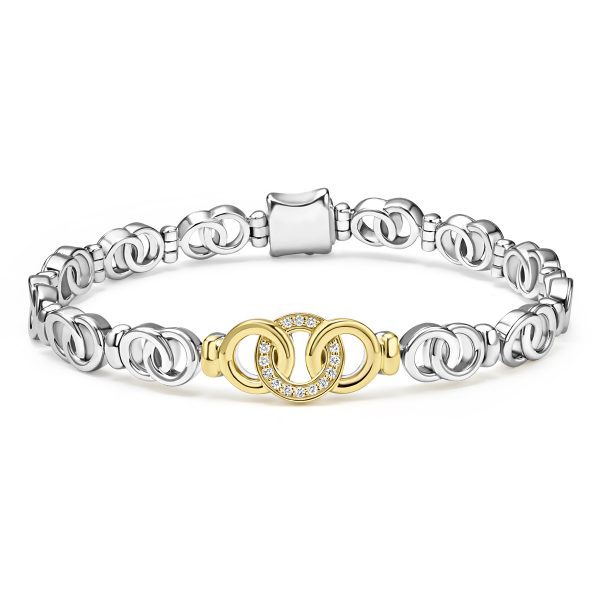 The LAGOS Signature Caviar Two-Tone Interlocking Diamond Link Bracelet features a series of interconnected oval links in a sleek, polished finish, complemented by a gold-toned central clasp adorned with small, sparkling crystals. This bracelet exudes a modern, elegant design.