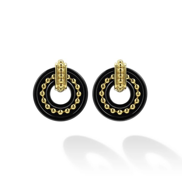 Introducing the LAGOS Black Caviar 18K Gold and Black Ceramic Stud Earrings: This exquisite pair features black circular rings with a delicate gold circular design inside, topped with a decorative gold clasp. These earrings create an elegant and modern look, perfectly showcased against a white background where their shadow is visible.