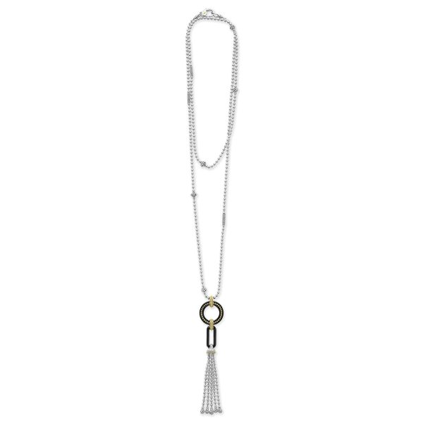 The LAGOS Black Caviar Two-Tone Black Ceramic Tassel Pendant Necklace is a long silver necklace featuring an elegant tassel pendant. The pendant includes a large ring, a cylindrical component, and cascading silver chains forming the tassel. Small silver beads adorn the chain, adding to its modern and sophisticated design.