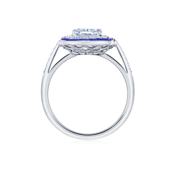 Side view of the Bromberg's Signature Collection diamond engagement ring, showcasing a brilliant diamond elegantly set above a detailed basket setting with an additional blue sapphire accent stone underneath. The band is sleek and polished.