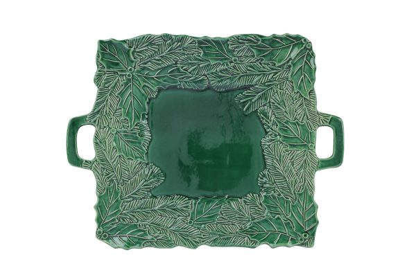 A square green ceramic serving tray features intricate leaf patterns around the edges and two side handles, creating a botanical theme. The center is smooth and glossy, offering a contrast to the textured border.