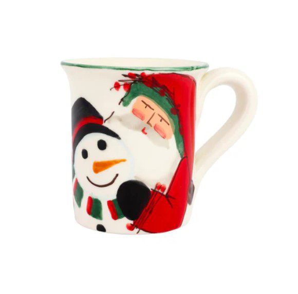 The Vietri Old St. Nick 2024 Limited Edition Mug is a festive ceramic piece featuring a snowman adorned with a carrot nose and coal buttons, sporting a black hat and scarf. Adjacent to the snowman is a small red bird perched on a green wreath. The mug is designed with a green rim and white handle.