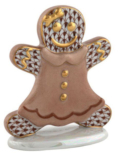 The Herend Gingerbread Girl Figurine - Chocolate showcases a decorative gingerbread figure dressed in a crown and adorned with gold accents. It stands on a white base, featuring an intricate patterned design, a cheerful smile, and outstretched arms.