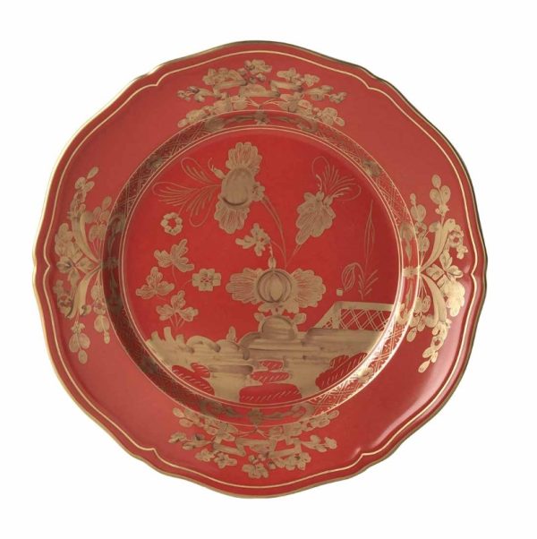 Introducing the Ginori 1735 Oriente Italiano Dinner Plate - Rubrum: a stunning red plate adorned with an intricate gold floral and landscape design, showcasing detailed flowers, leaves, and a bridge-like structure. The piece is elegantly framed by a scalloped edge.