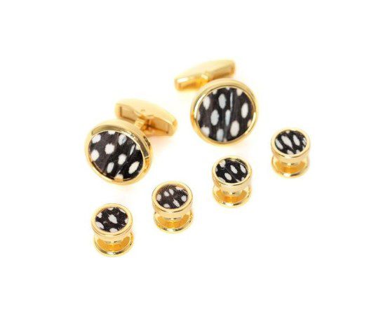 The Brackish Cuff Link Set - Bear features gold cufflinks and buttons with a black and white spotted pattern in the center. This design boasts a circular shape and a glossy finish, all elegantly arranged on a white background.