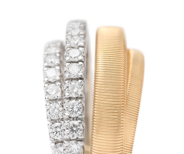 Displayed against a plain white background, the Marco Bicego Yellow Gold 4-Strand Coil Ring with Pavé Diamond features one elegantly textured gold coil ring alongside a silver band adorned with a row of small diamonds.