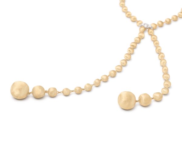 The Marco Bicego Africa Yellow Gold Lariat Necklace with Diamond Pavé Clasp showcases a Y-shape design adorned with a row of small, round beads and two larger, textured beads at the ends, offering a stylish and elegant appearance.