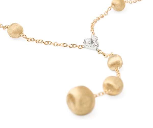 The Marco Bicego Yellow Gold Lariat Necklace features a chain adorned with textured gold beads and a central silver setting holding three small diamonds, elegantly highlighted against a white background.