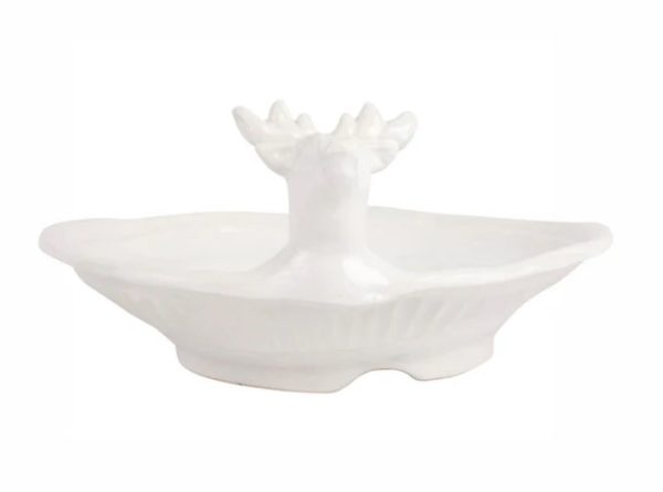 The Vietri Pietra Natale Figural Deer Shallow Bowl is a white ceramic dish featuring a reindeer head with antlers at the center and a wavy-edged design, combining functionality with a decorative touch.