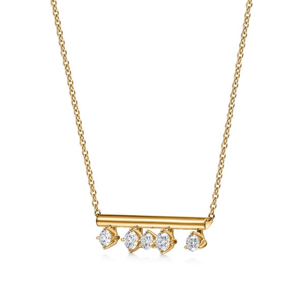 The Hearts on Fire Barre Floating Diamond Pendant Necklace showcases a horizontal gold bar adorned with five dazzling round diamonds hanging gracefully on a delicate chain, offering a simple and elegant design.